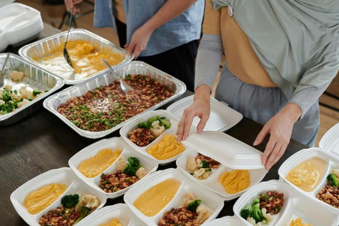 Manos empacando alimentos con empaques compostables de BioFusión en Costa Rica.